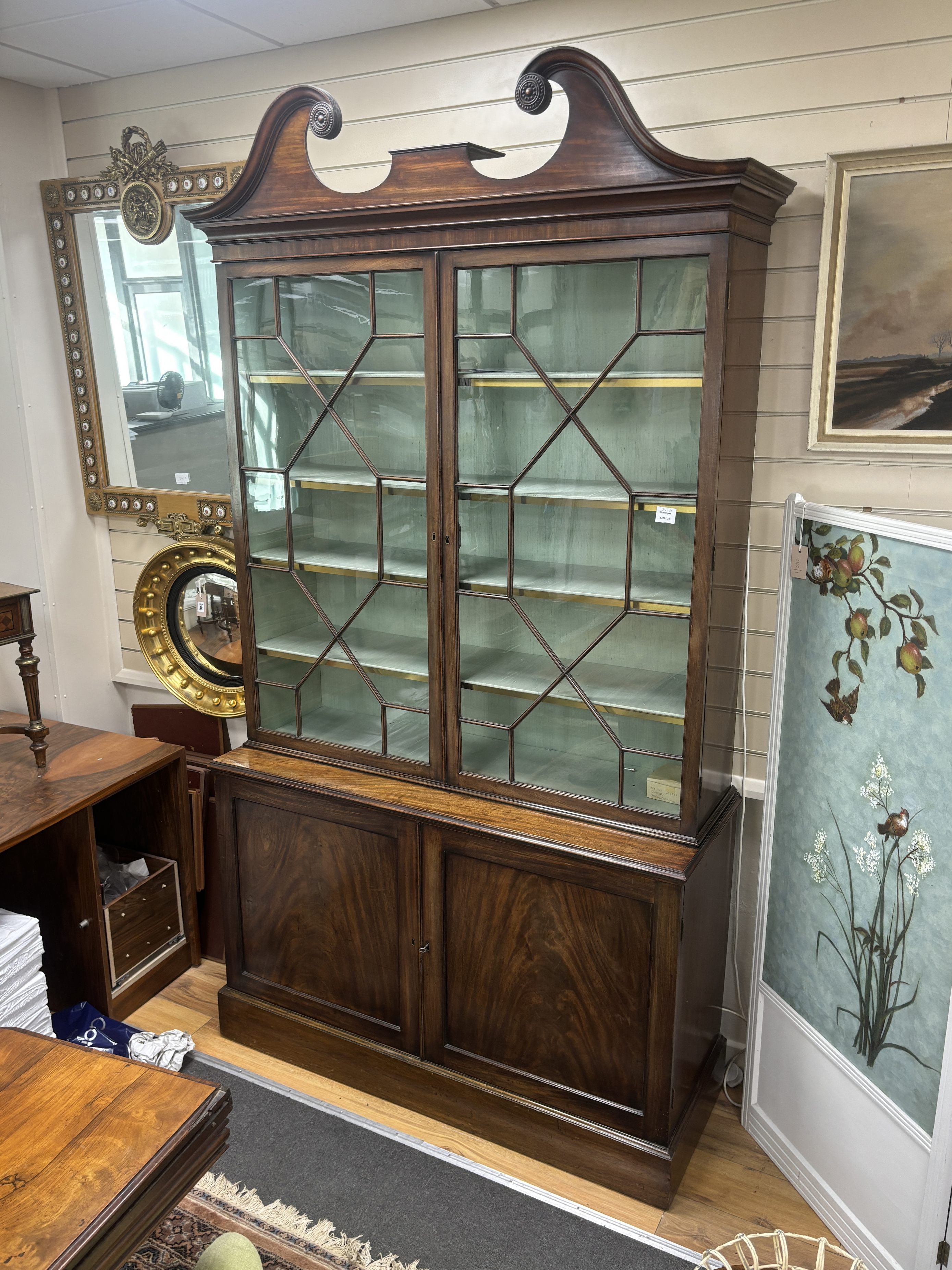 A George III and later mahogany library bookcase with swan neck pediment, width 130cm, depth 46cm, height 241cm